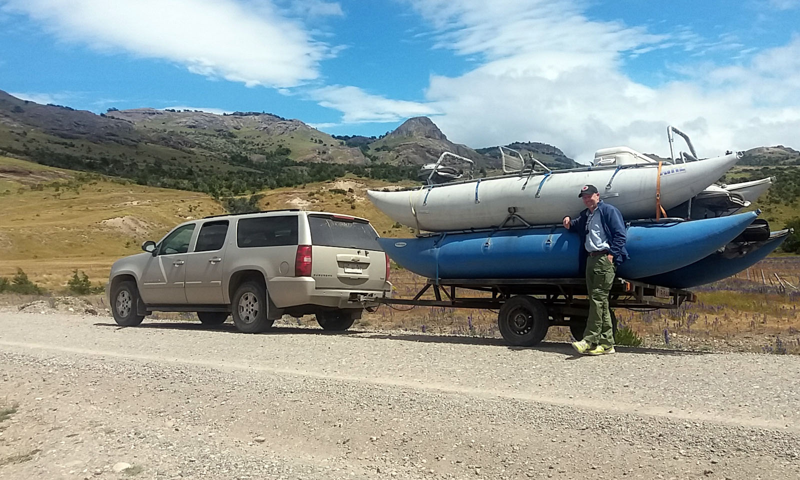 A spacious SUV with capacity to comfortably seat 7 people pulls a trailer with 2 cataraft drift boats on a road trip in Patagonia Chile.